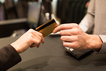 Image showing close up of hand giving credit card to seller