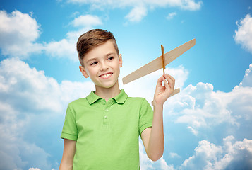 Image showing happy boy in green polo t-shirt with toy airplane