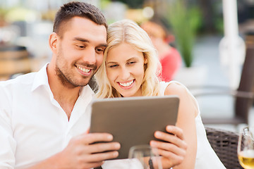 Image showing happy couple with tablet pc at restaurant lounge