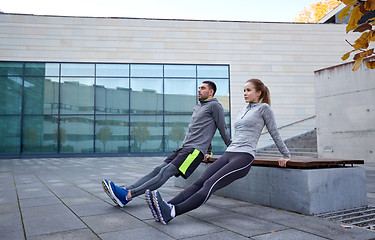 Image showing couple doing triceps dip exercise outdoors