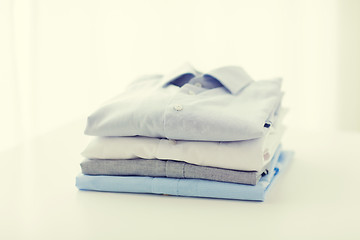 Image showing close up of ironed and folded shirts on table