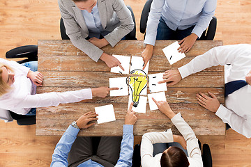 Image showing close up of business team with light bulb puzzle
