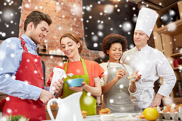 Image showing happy friends and chef cook baking in kitchen