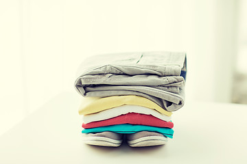 Image showing close up of folded shirts and boots on table