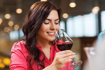 Image showing smiling woman drinking red wine at restaurant