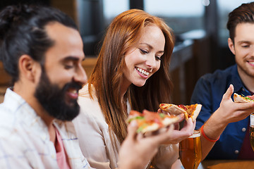 Image showing friends eating pizza with beer at restaurant