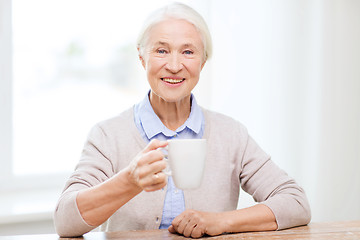 Image showing happy senior woman with cup of tea or coffee