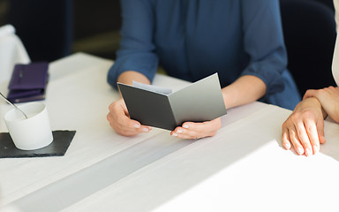 Image showing close up of woman hands holding restaurant bill