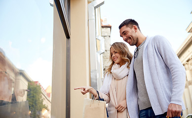 Image showing happy couple with shopping bags at shop window