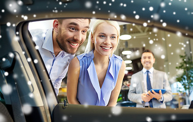 Image showing happy couple looking inside car in auto show