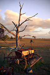 Image showing old plough on farm at sunset
