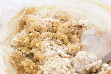 Image showing Cookie dough being mixed with a wooden spoon