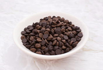 Image showing Dish of milk and dark chocolate chips