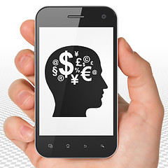 Image showing Business concept: Hand Holding Smartphone with Head With Finance Symbol on display