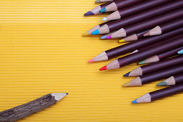 Image showing Colored pencils on yellow cardboard background