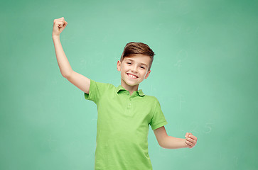 Image showing happy school boy in t-shirt showing strong fists