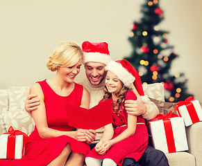 Image showing smiling family reading postcard