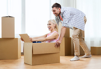 Image showing couple with cardboard boxes having fun at new home