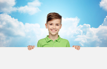 Image showing happy boy in t-shirt holding white blank board