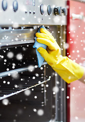 Image showing close up of woman cleaning oven at home kitchen