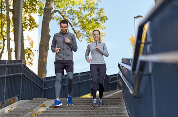 Image showing happy couple running downstairs in city