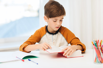 Image showing student boy reading book or textbook at home