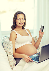 Image showing pregnant woman with laptop and credit card at home