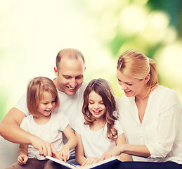 Image showing happy family with book at home