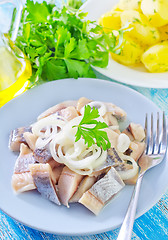 Image showing herring with onion on blue plate