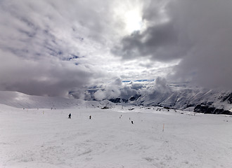 Image showing Skiers on ski slope before rain