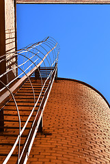 Image showing Industrial ladder, blue sky and brick walls of the building