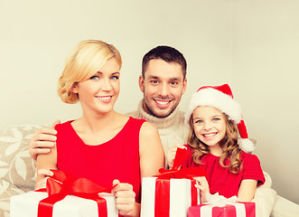 Image showing smiling family holding many gift boxes