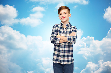 Image showing smiling boy in checkered shirt over blue sky