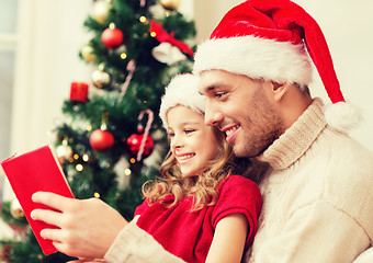 Image showing smiling father and daughter reading book