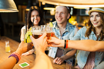 Image showing happy friends clinking glasses at bar or pub