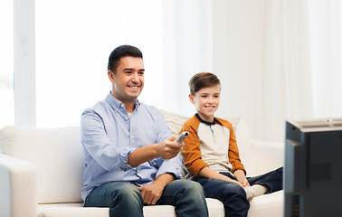 Image showing smiling father and son watching tv at home