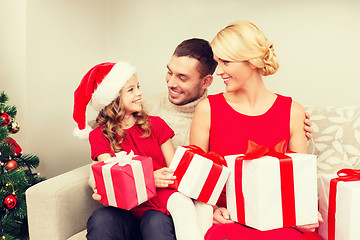 Image showing smiling family holding many gift boxes