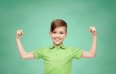 Image showing happy boy in polo t-shirt showing strong fists
