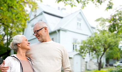 Image showing senior couple hugging over living house background