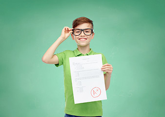 Image showing happy boy in eyeglasses holding school test result