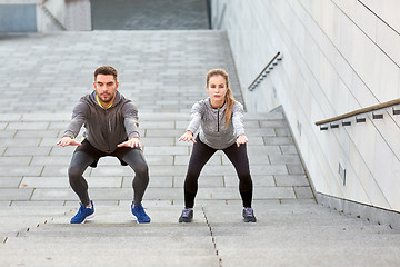 Image showing couple doing squats and exercising outdoors