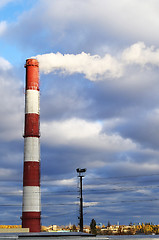 Image showing Pipe industrial chimney with smoke against the sky and clouds