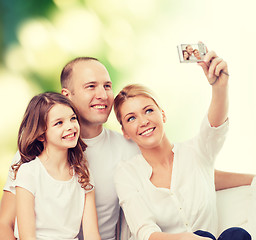 Image showing happy family with camera at home