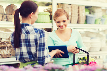 Image showing happy women with tablet pc at flower shop