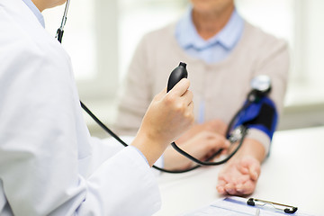 Image showing doctor with tonometer and senior woman at hospital