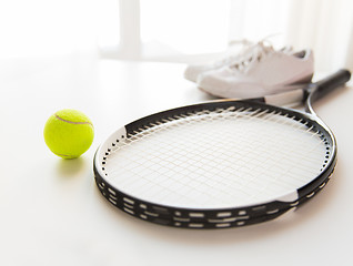 Image showing close up of tennis racket with ball and sneakers