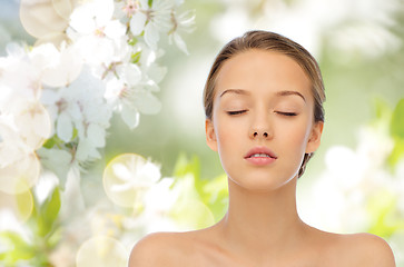 Image showing young woman face over cherry blossoms