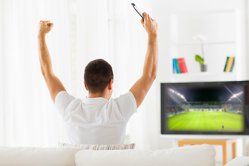 Image showing happy man watching football on tv at home