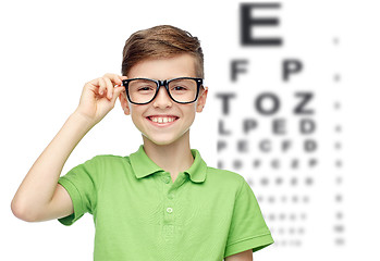 Image showing happy boy in eyeglasses over eye chart