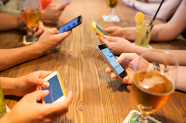 Image showing close up of hands with smartphones at restaurant